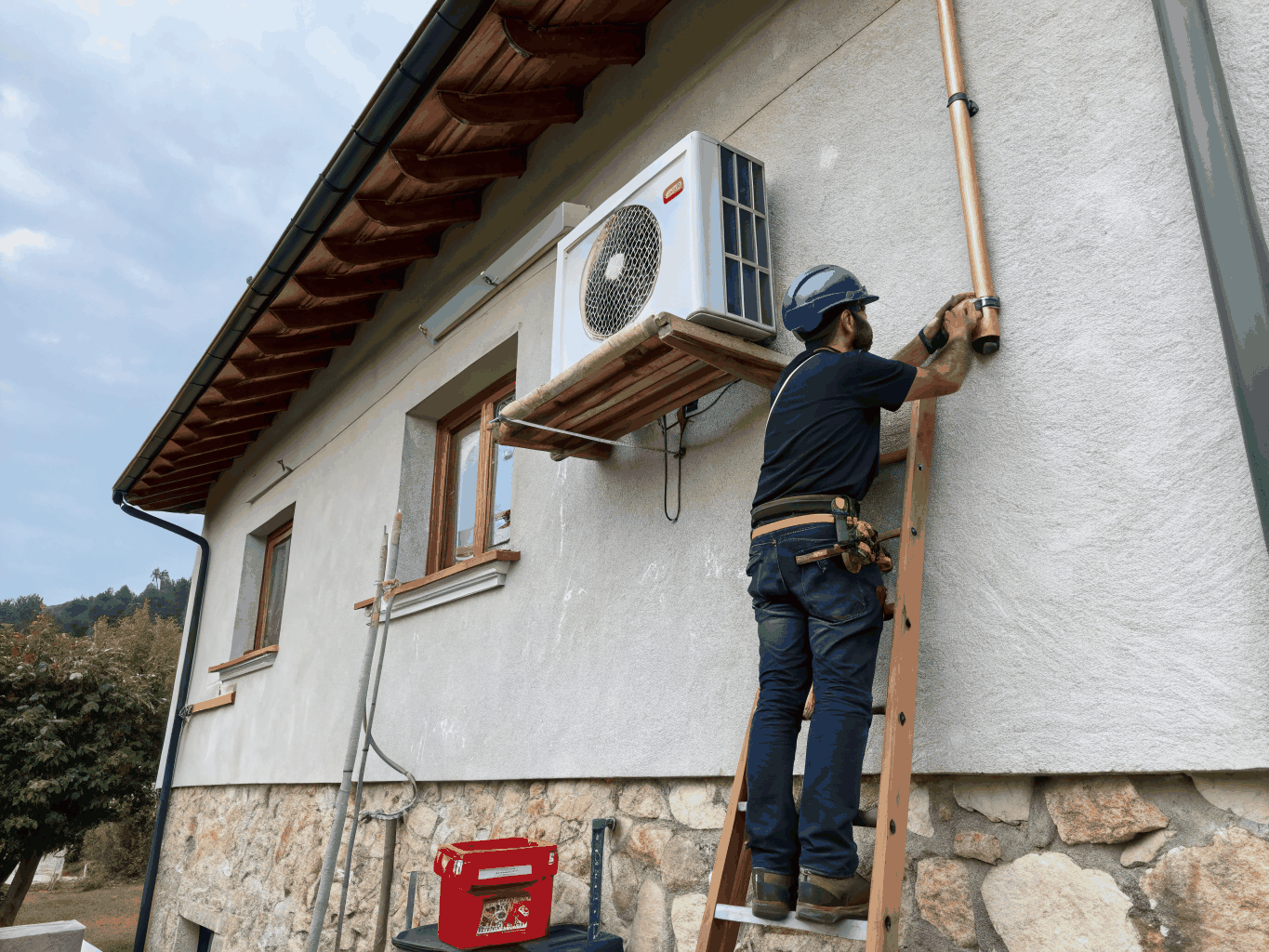 Technician installing modern energy efficient outdoor heat pump system